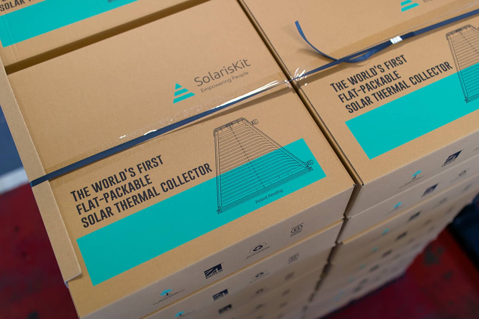 SolarisKit flat-packed solar collectors stacked on pallet